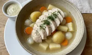 Varm kycklingsoppa med potatis, morötter och lök. En klick krämig sås står bredvid. Perfekt innertemp kycklingfile för en mysig middag.