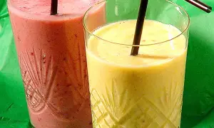 Två glas med färgglada smoothies, ett rosa och ett gult. Perfekt för ett snabbt smoothie recept.