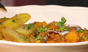 En portion pytt Bellman med stekt potatis, inlagd gurka och ansjovis, toppad med persilja.