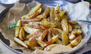 Klyftpotatis i airfryer, gyllene och krispiga, serverade med färsk rosmarin. Perfekt tillbehör!
