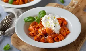 Krämig nduja pasta med burrata och färsk basilika, serverad på en vit tallrik.